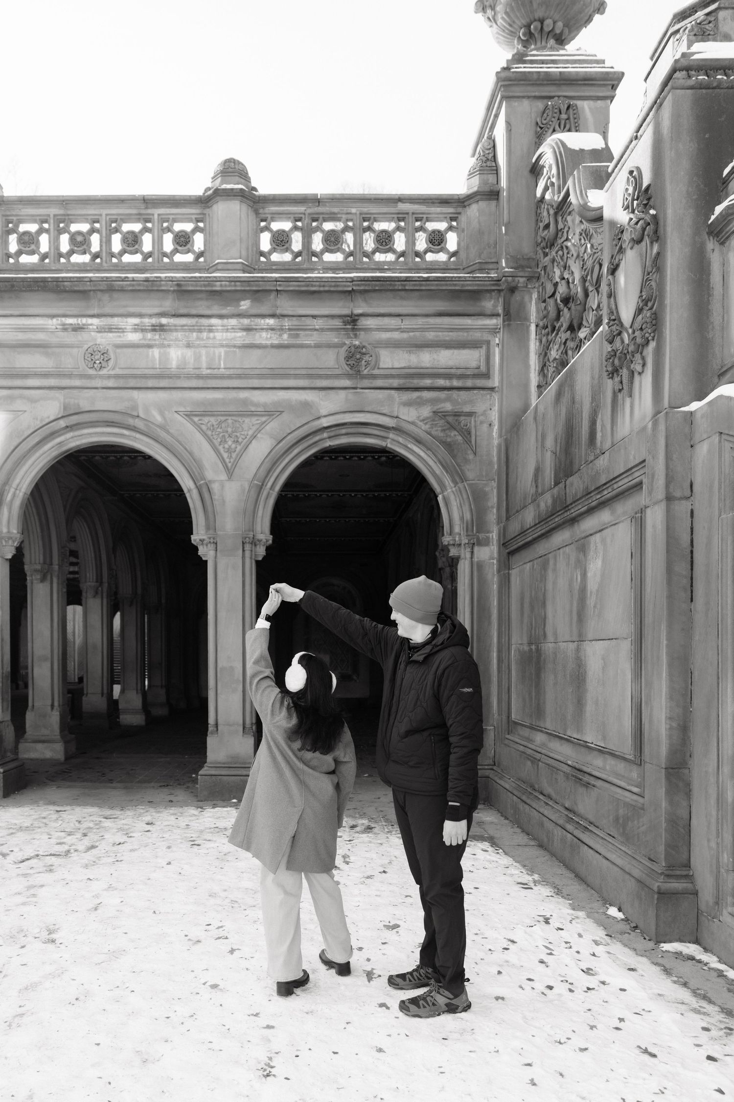 A series of black and white photographs showing figures walking through a snow-covered archway passage.