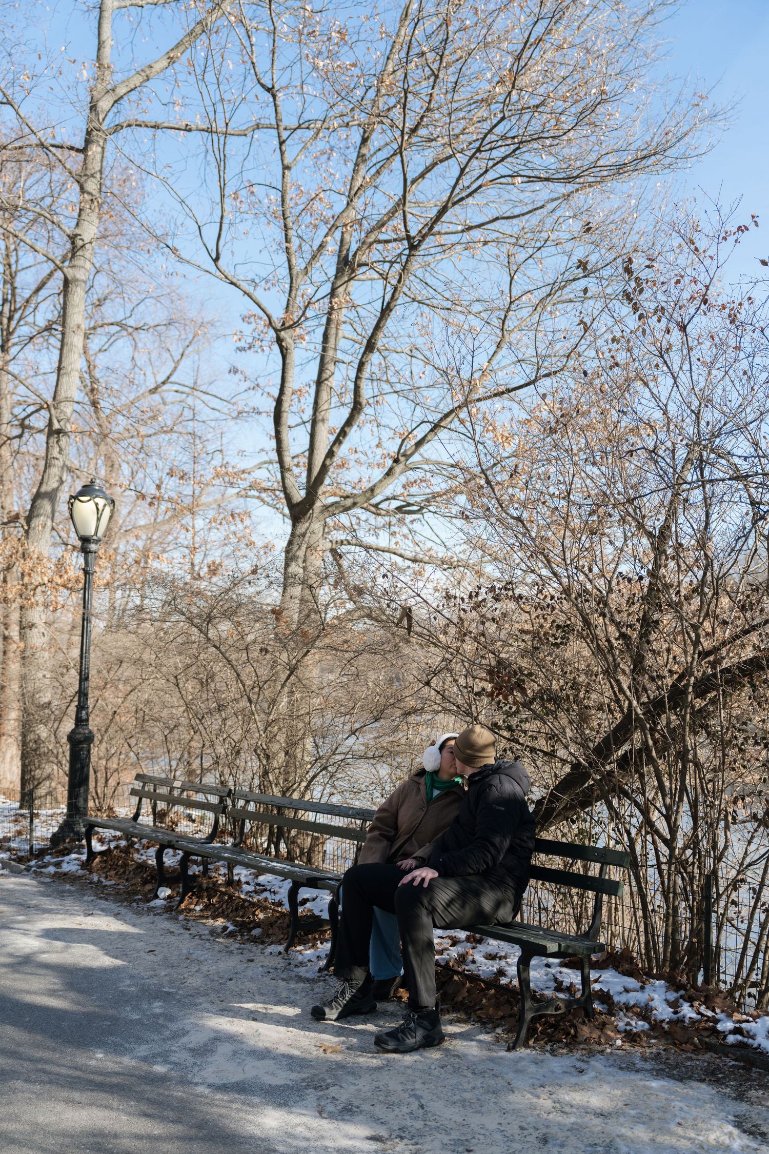 A sequence of four winter park bench scenes showing someone sitting and relaxing along a snowy path lined with bare trees.