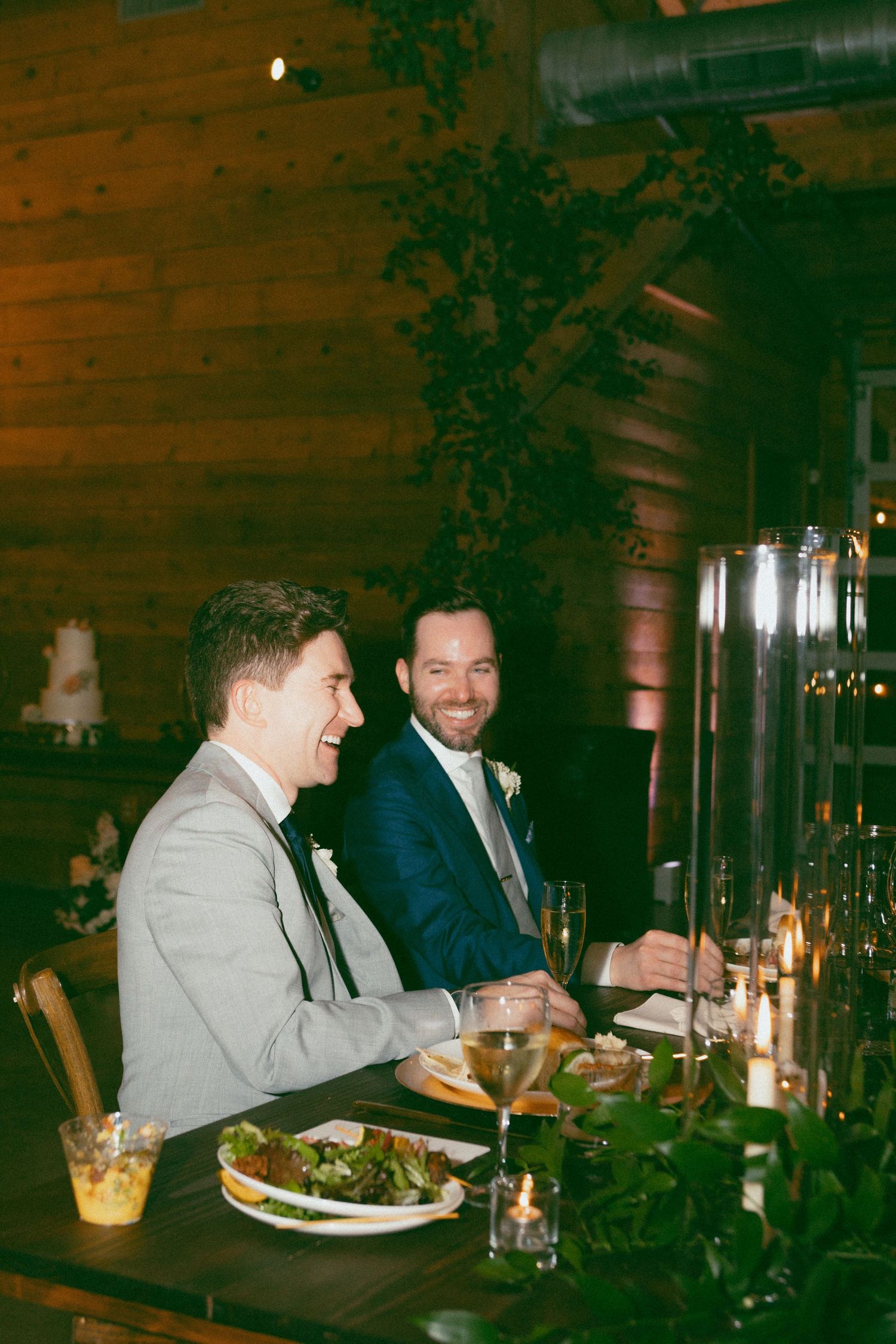 Candlelit dinner scene in a rustic wooden interior with warm ambient lighting.