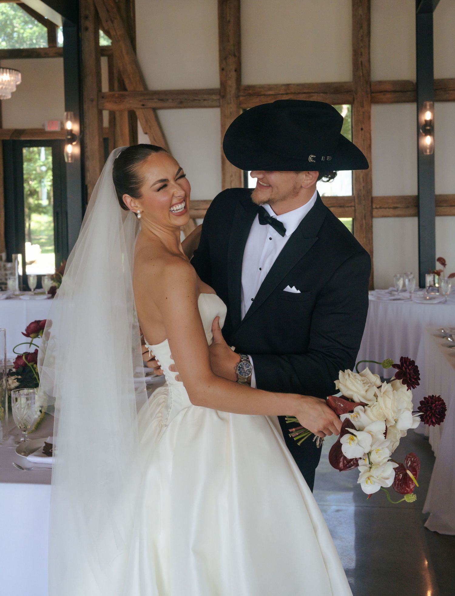 Romantic wedding dance sequence inside a rustic barn venue with exposed wooden beams.