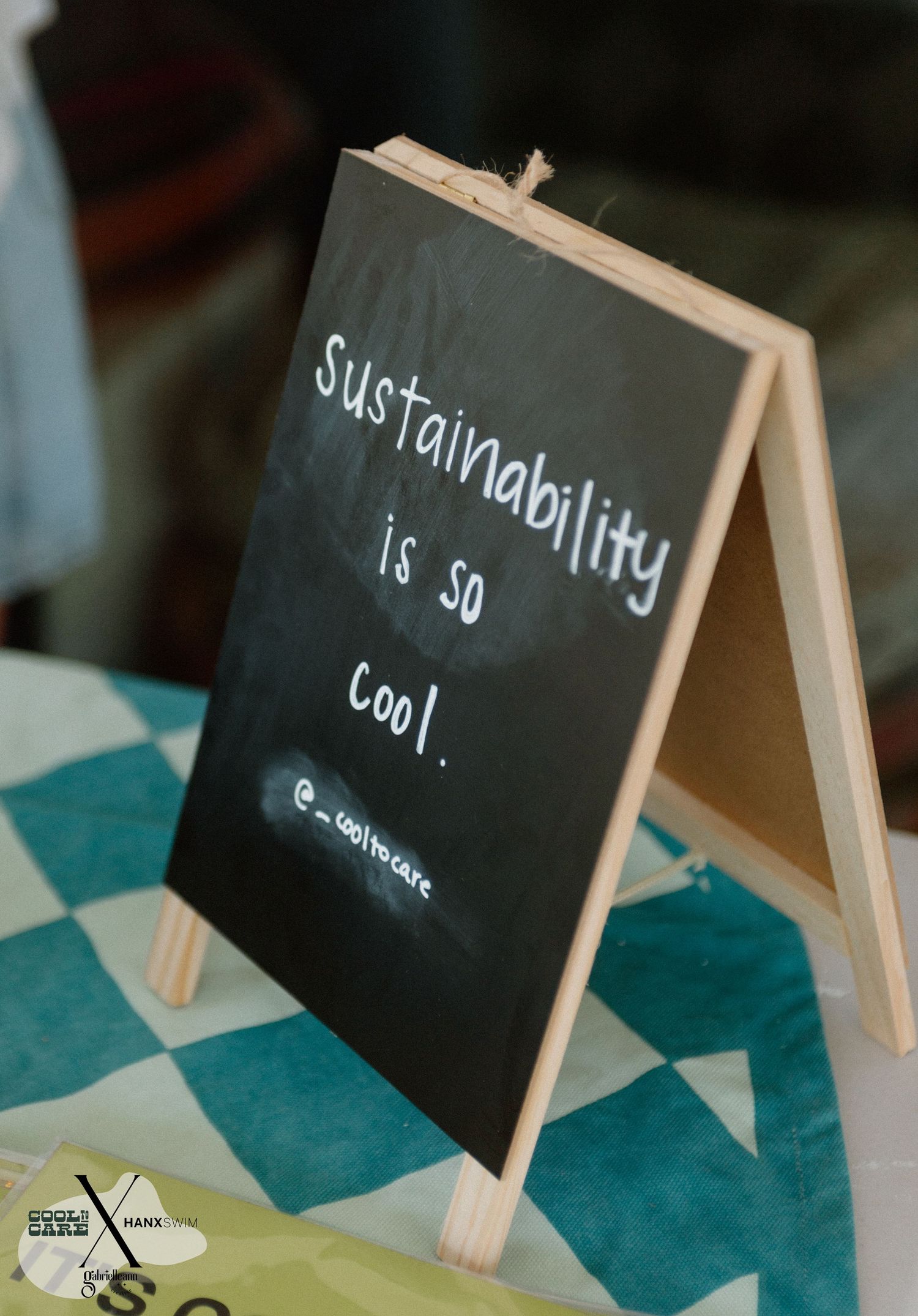 Small chalkboard signs with handwritten text displayed on turquoise checkered surface.