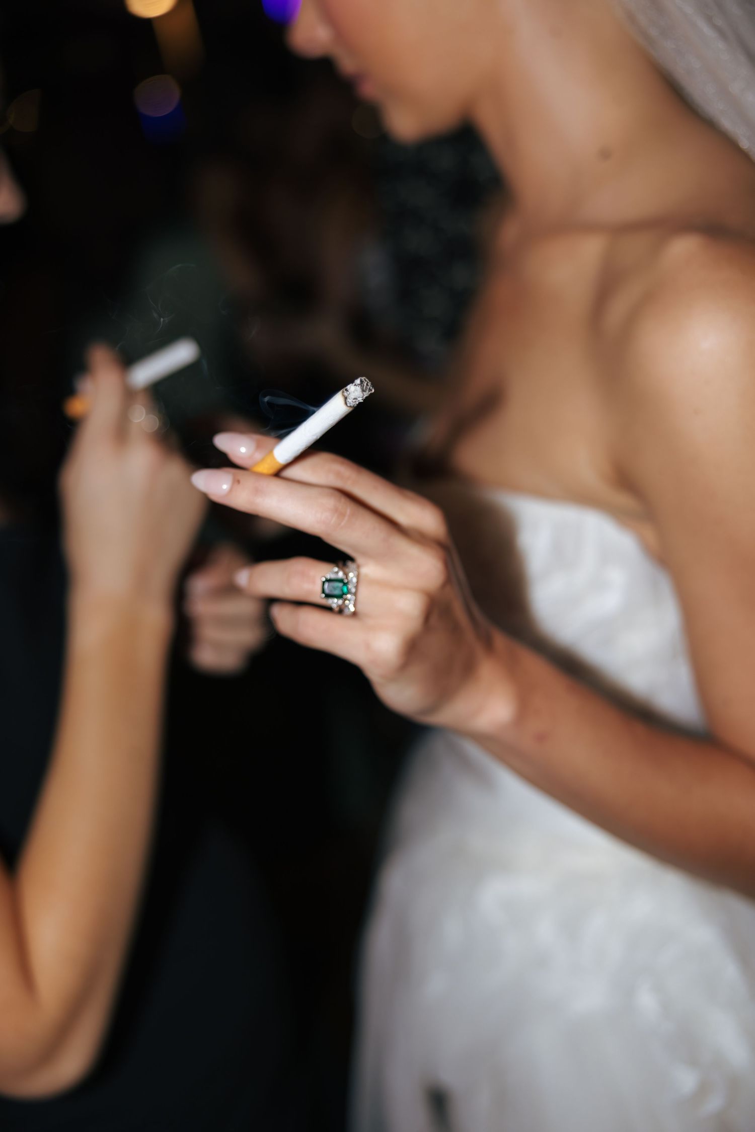 Close-up of a white dress and jewelry at a formal event.