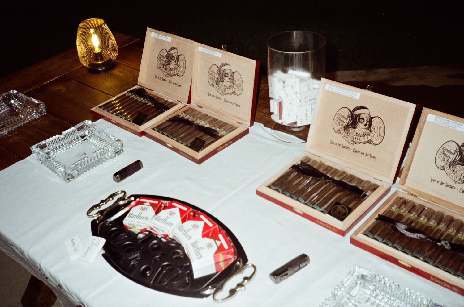 Wedding reception table displaying cigars and specialty items for guests.