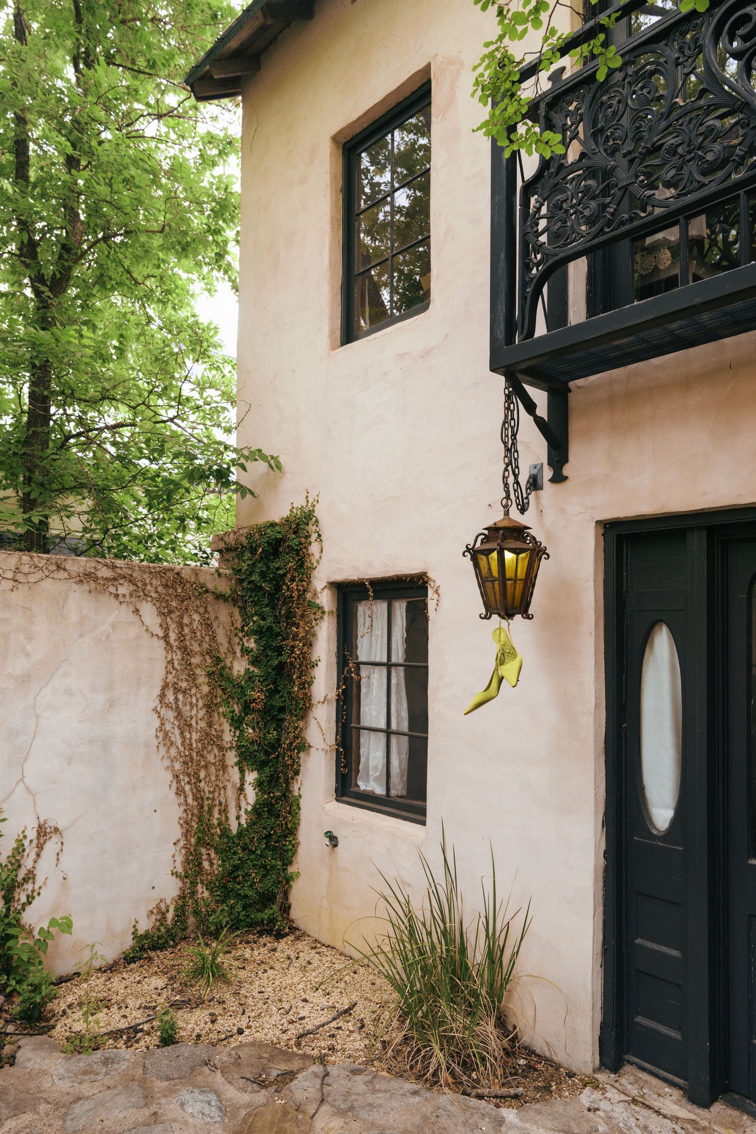 A series of exterior shots showing a pink stucco wall with black-framed windows and a hanging lantern fixture.