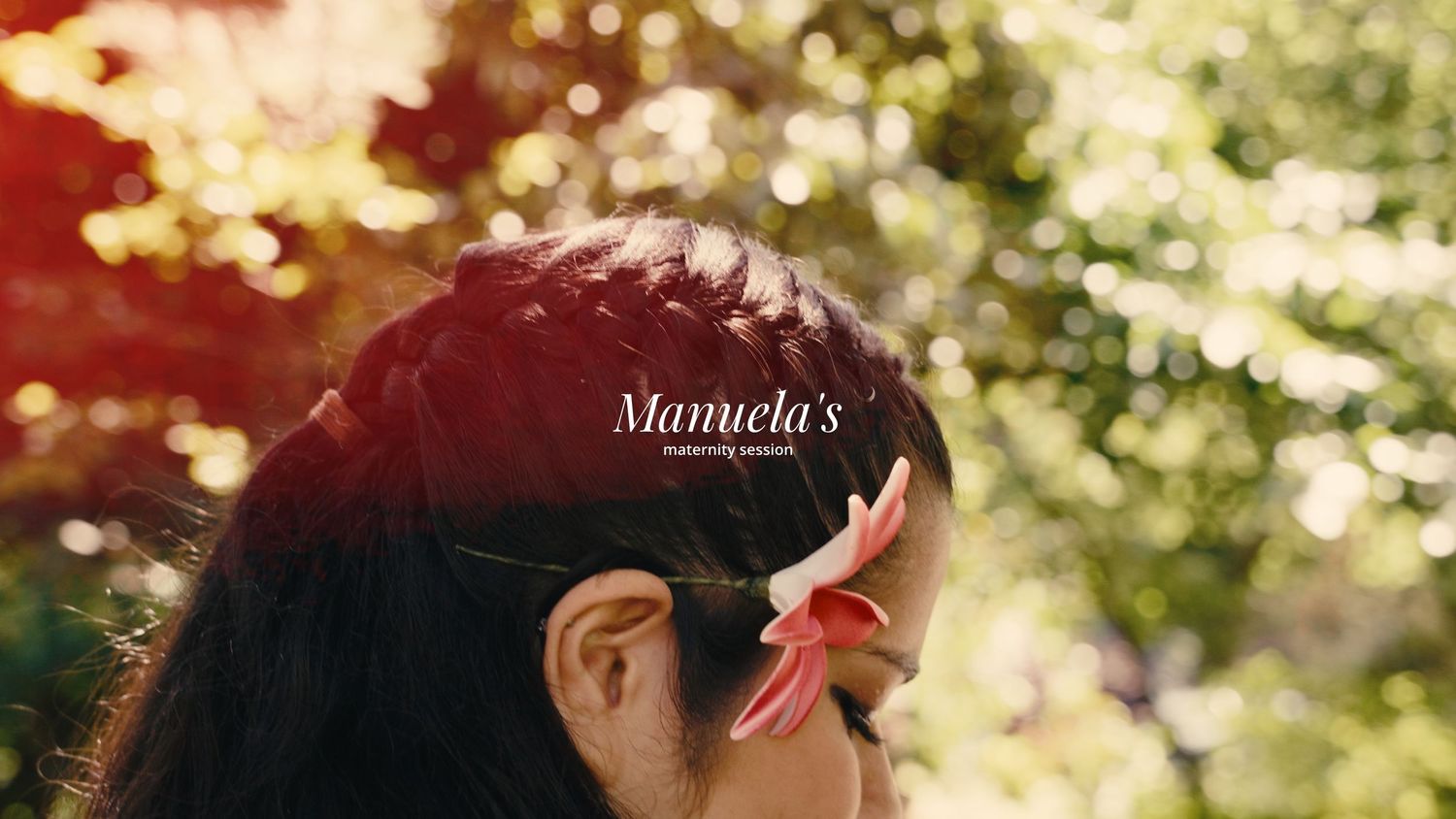 Woman with braided hair adorned with a red flower clip, Mamuela's branding overlay.