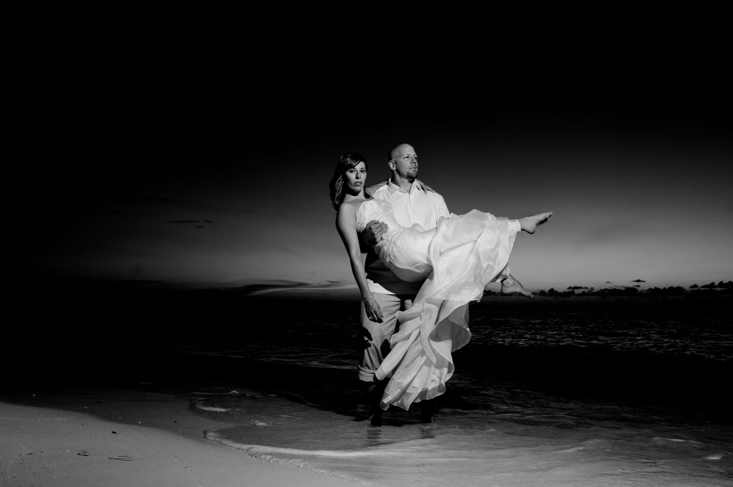 Dramatic black and white series of romantic wedding poses on a dark background.
