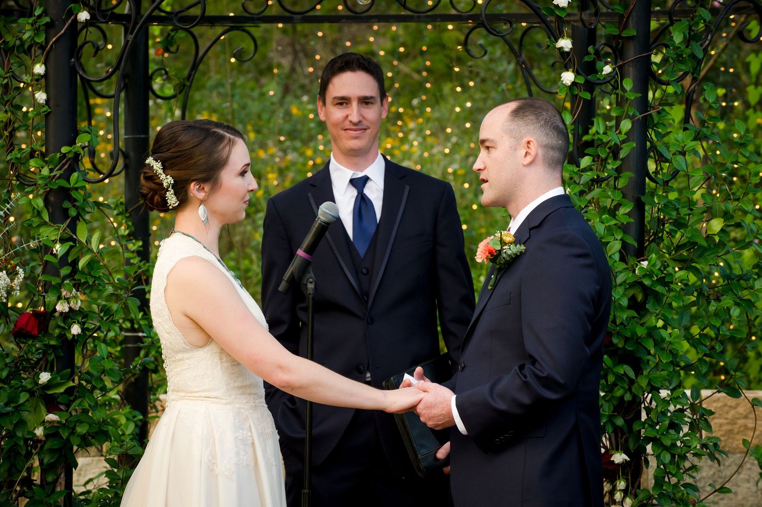 Outdoor wedding ceremony taking place in a lush garden setting with natural decor and florals.
