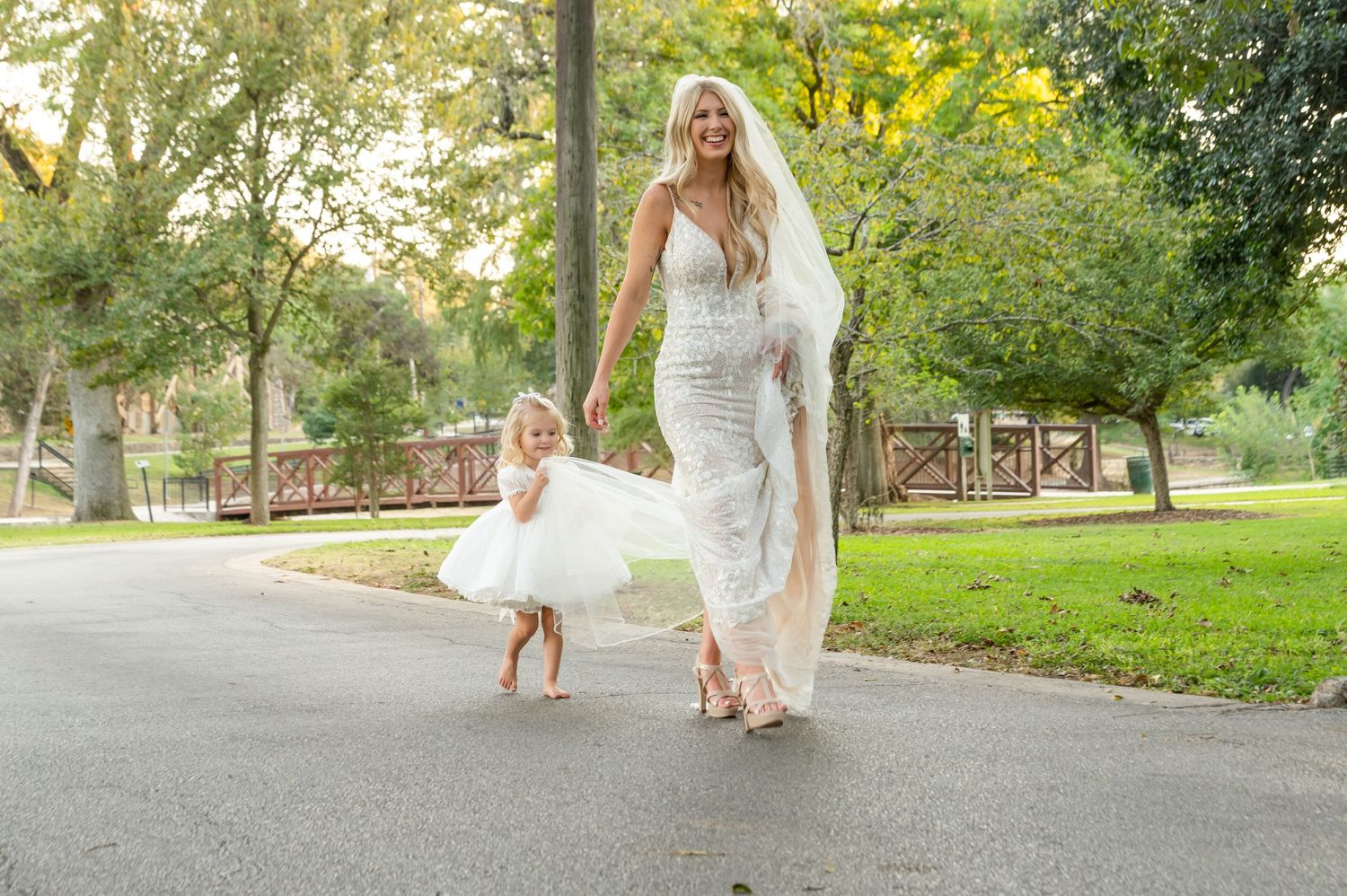Candid wedding moments captured on a paved pathway surrounded by green lawn.
