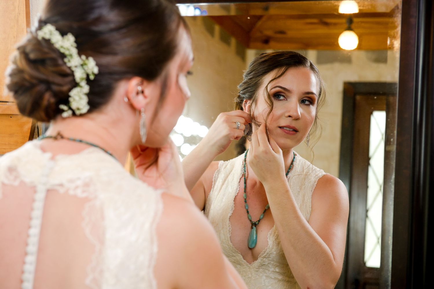 A bride and bridesmaids in turquoise dresses prepare for a wedding in an elegant indoor setting.