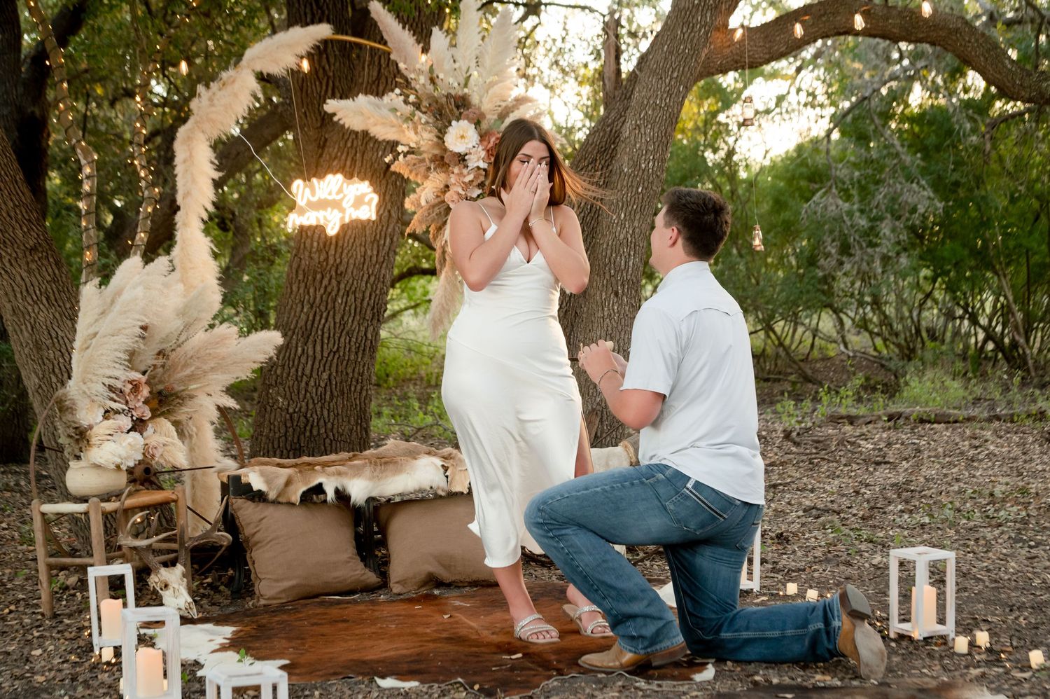 Romantic proposal setup in natural setting with decorative elements and soft lighting.