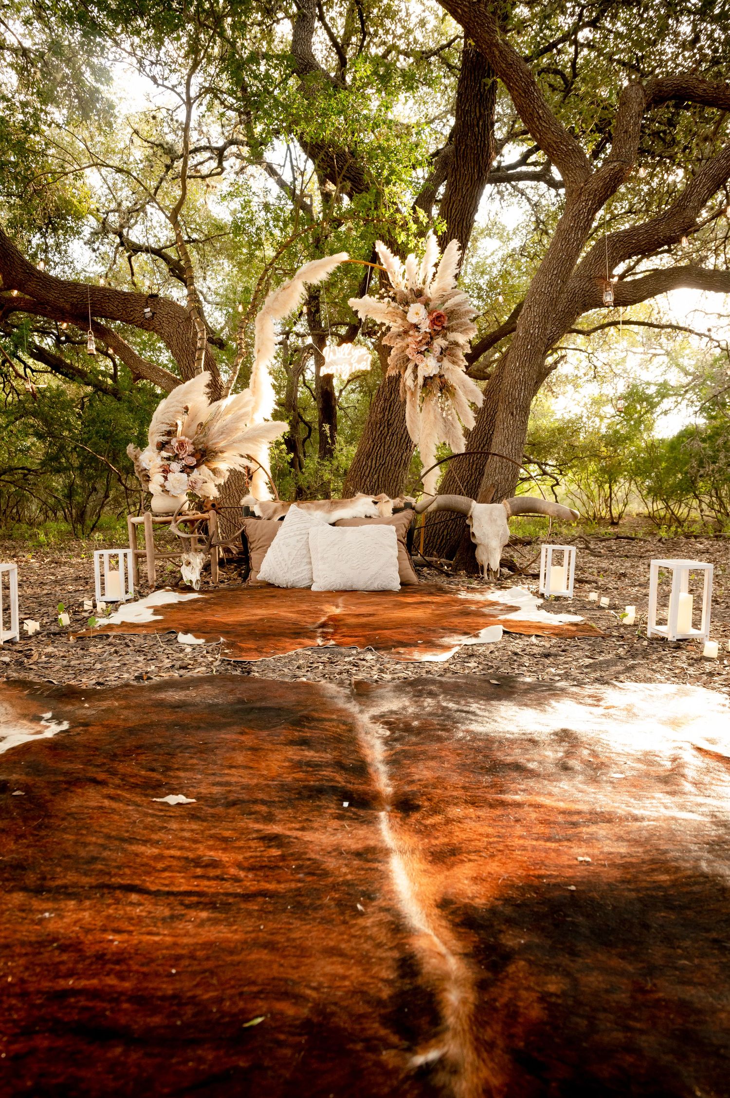 Dreamy outdoor setup with paper flowers and lanterns creating romantic ambiance under trees.