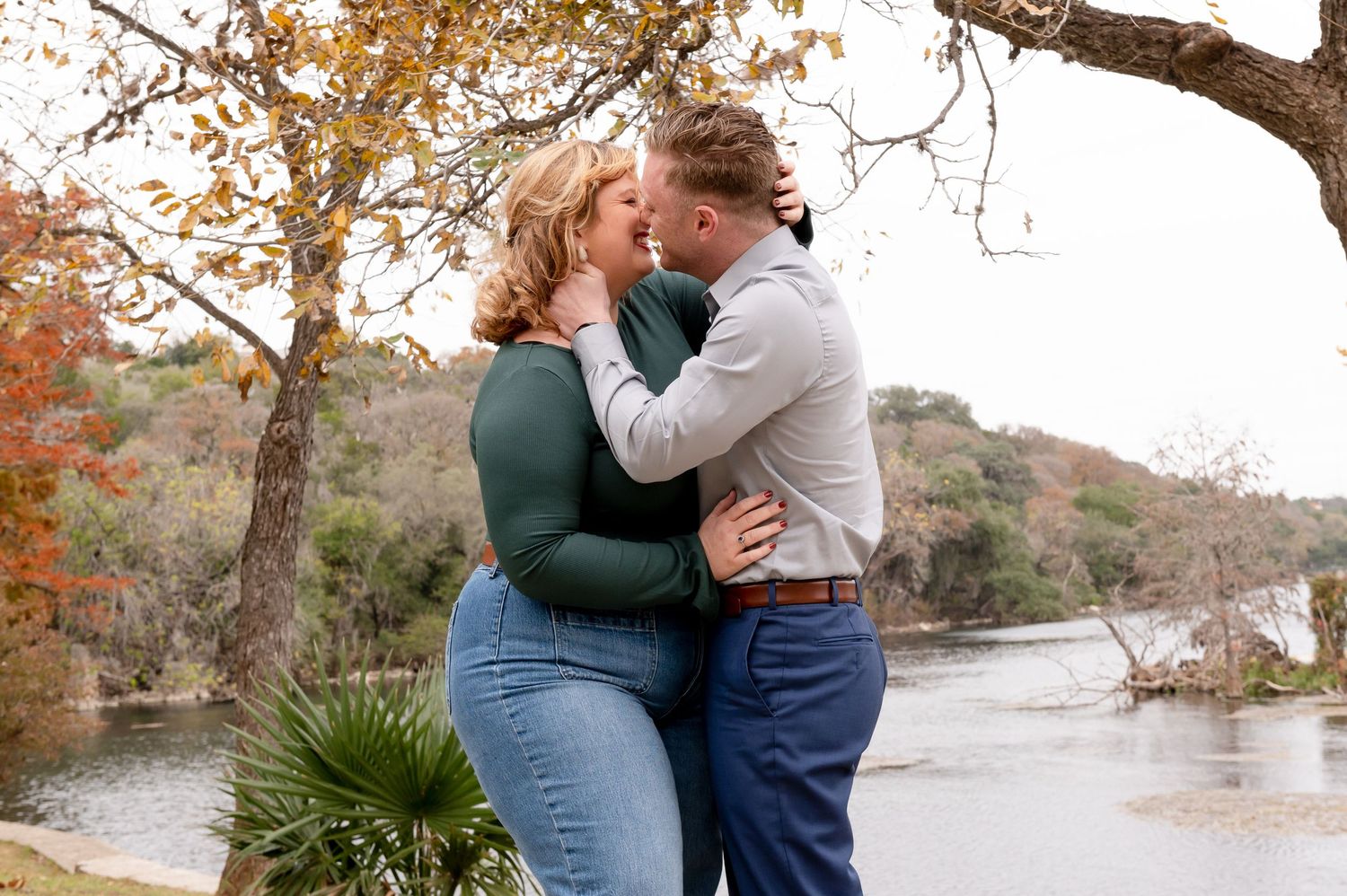 Romantic autumn engagement photos by the lake with fall foliage.