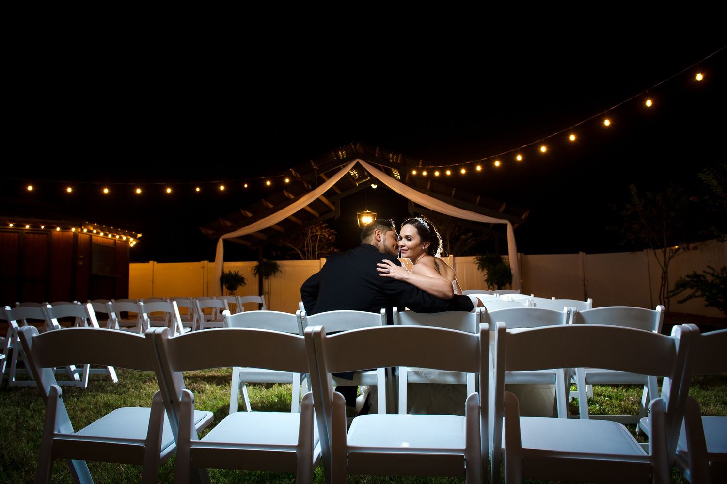Evening reception venue decorated with string lights creating warm ambient glow.