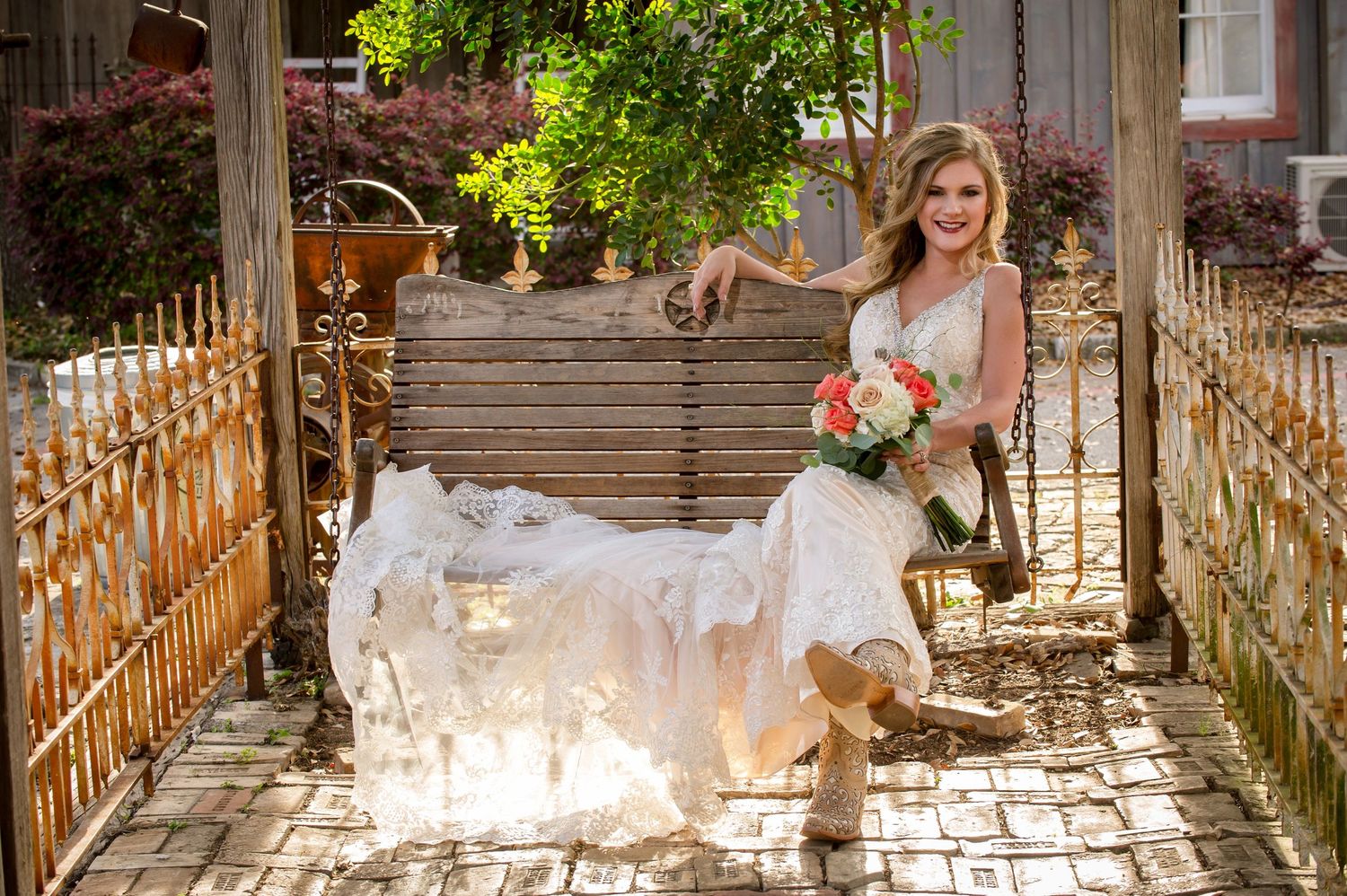A bride in a white wedding dress walks down a sunlit wooden porch with floral decorations.