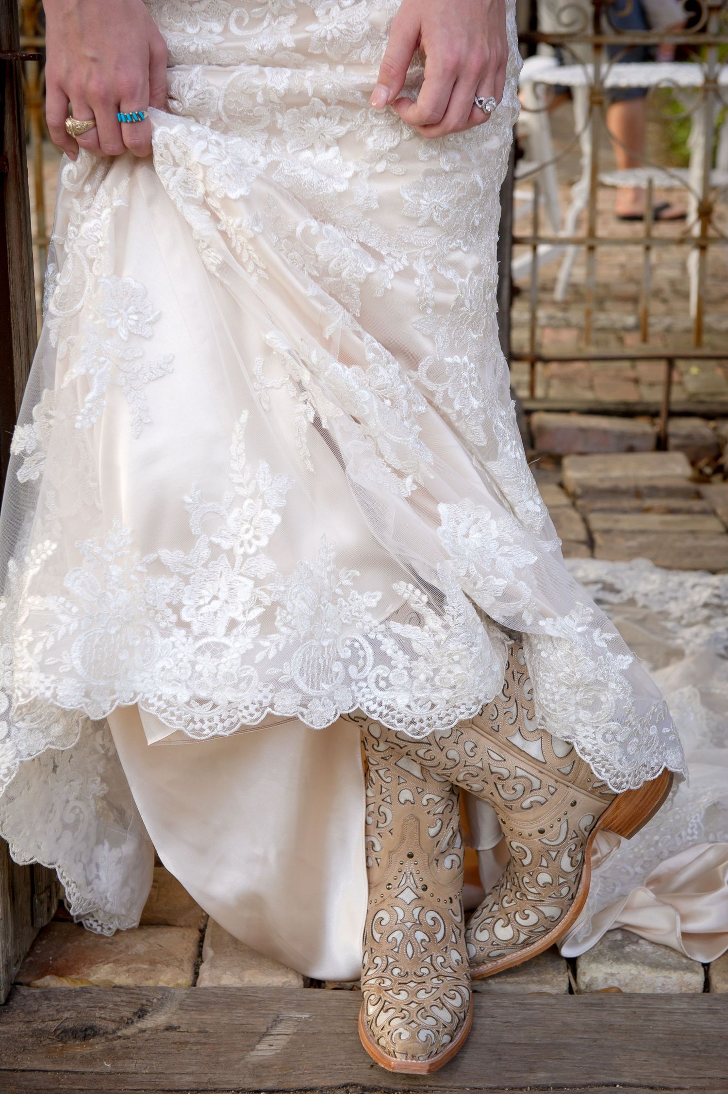 Close-up of intricate lace wedding dress hem and embellished bridal shoes.