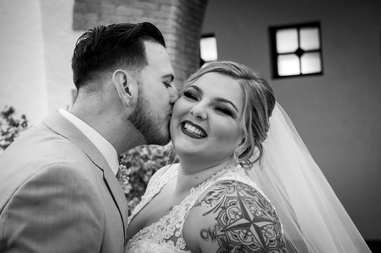 Black and white wedding ceremony photo capturing an intimate moment in an elegant venue.
