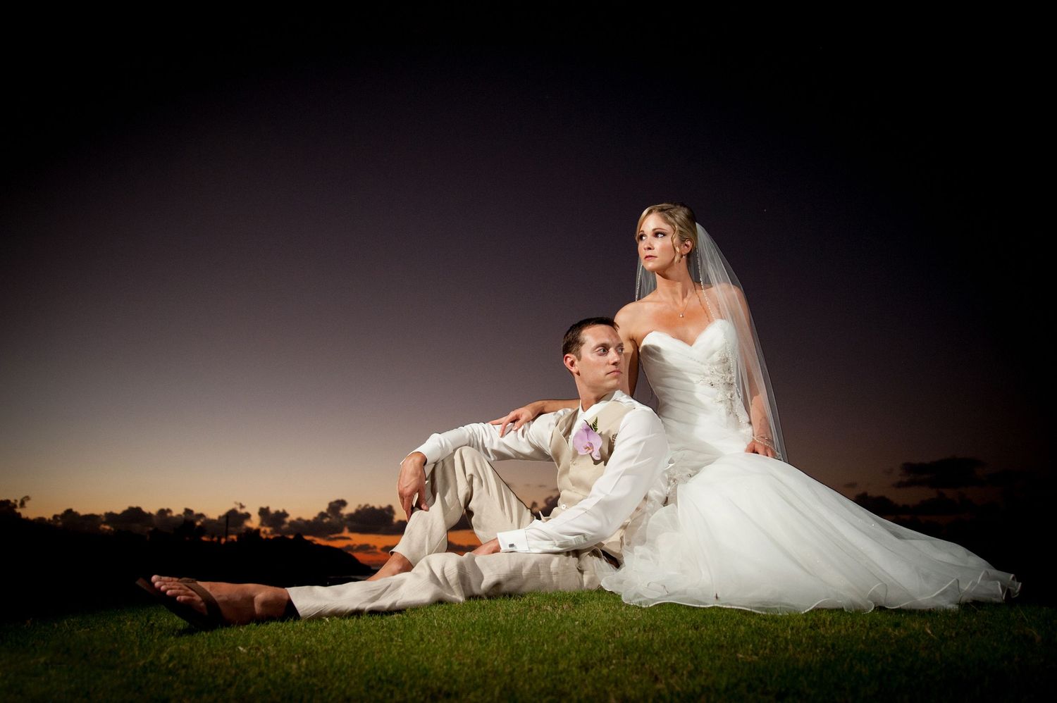 Dramatic bridal portraits on a dark background with elegant white wedding gown.