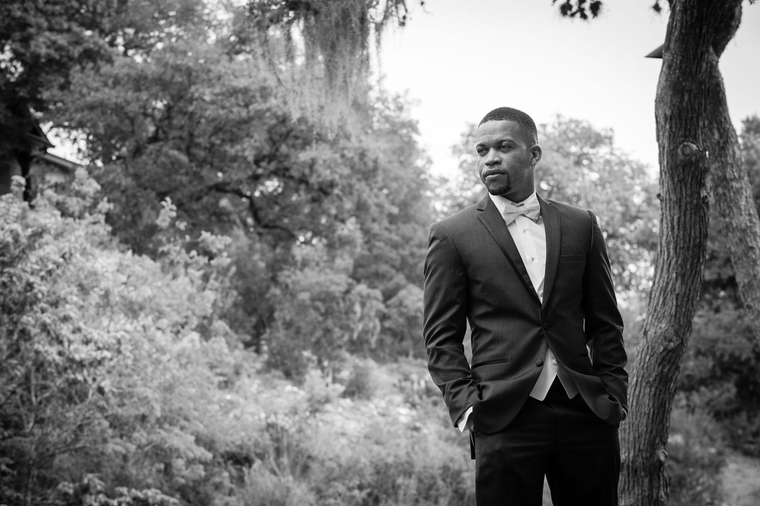 Black and white wedding portraits captured among trees in natural outdoor setting.