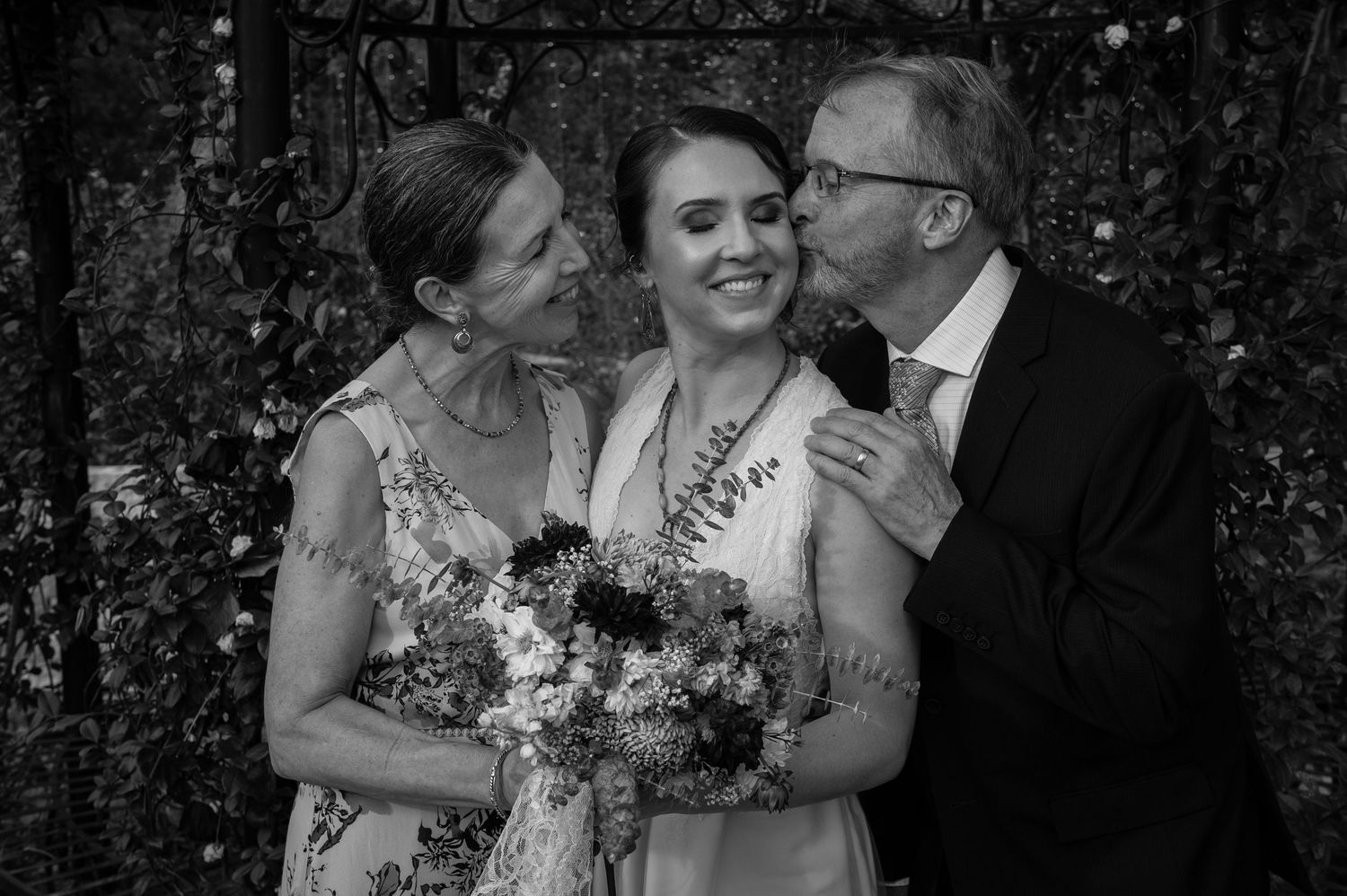 Black and white candid moment with bouquet and smiles.