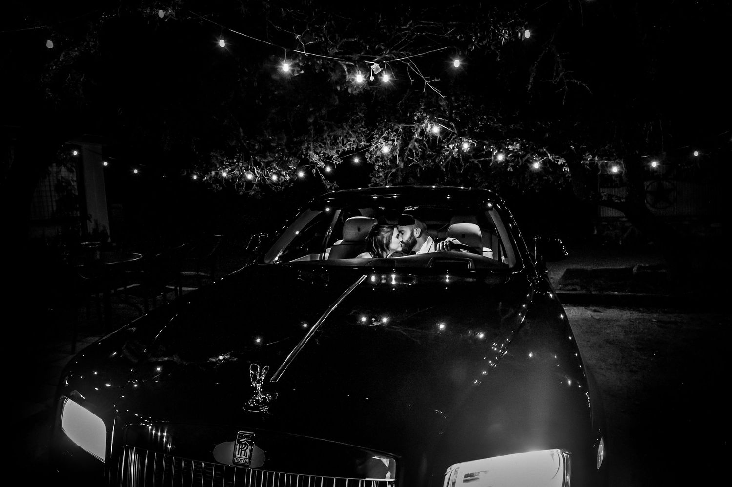 Nighttime wedding celebration with string lights creating a magical atmosphere.