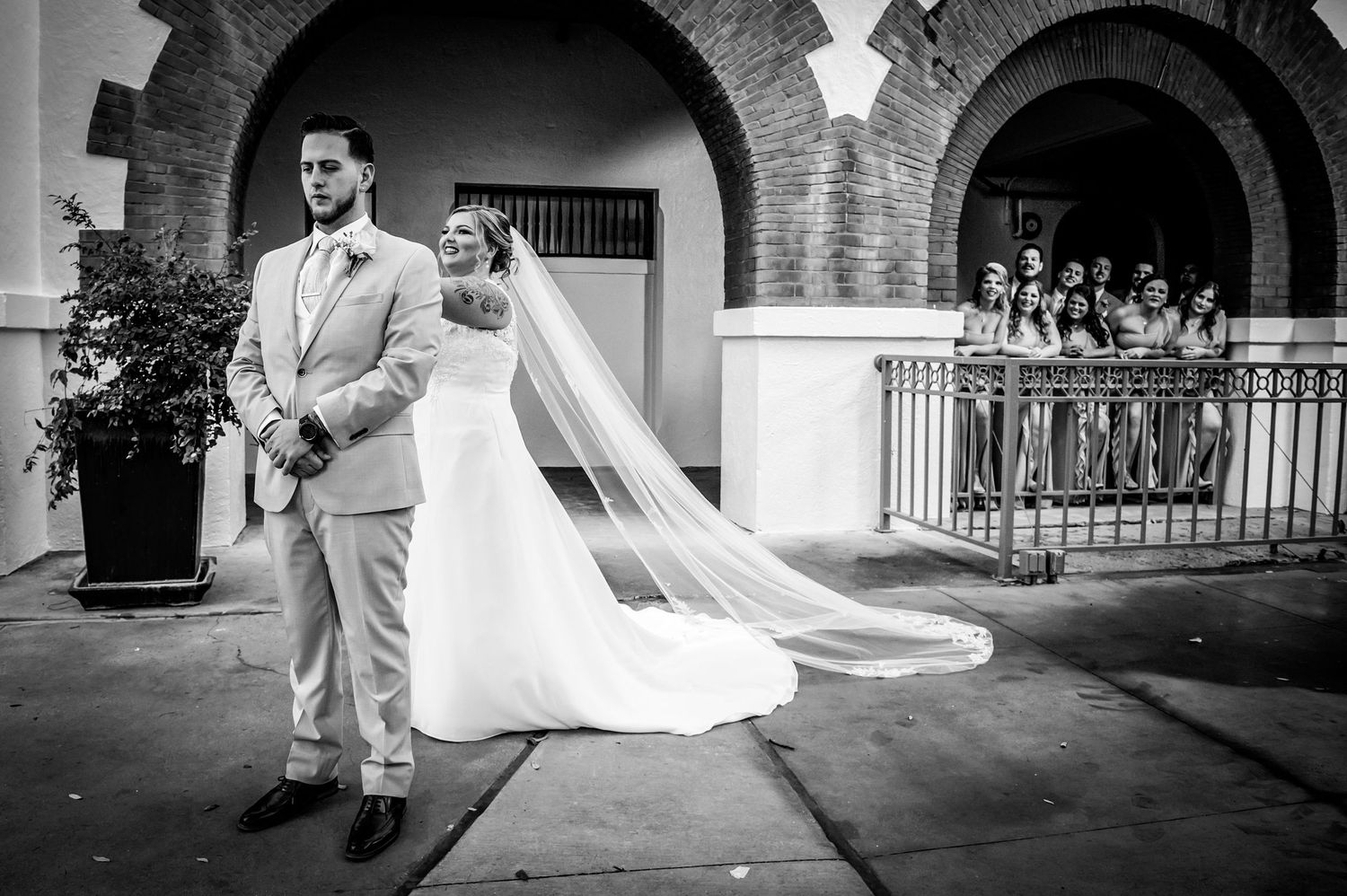 An elegant wedding photo session under historic stone archways with dramatic lighting.