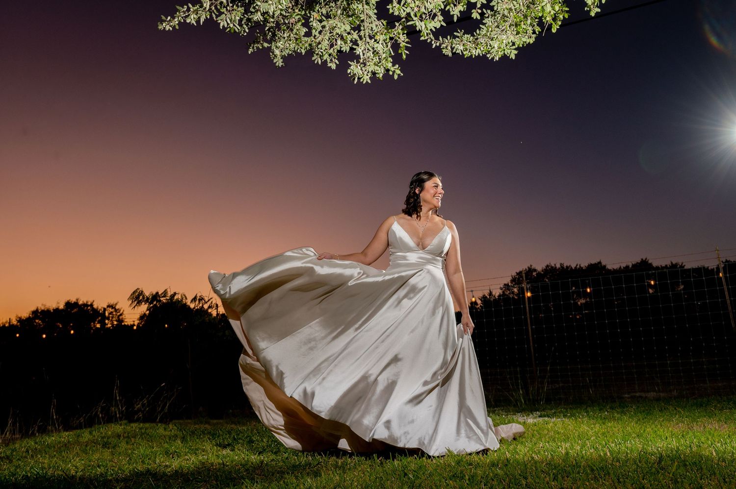 Stunning sunset wedding portraits in an outdoor field with dramatic lighting and flowing white dress.