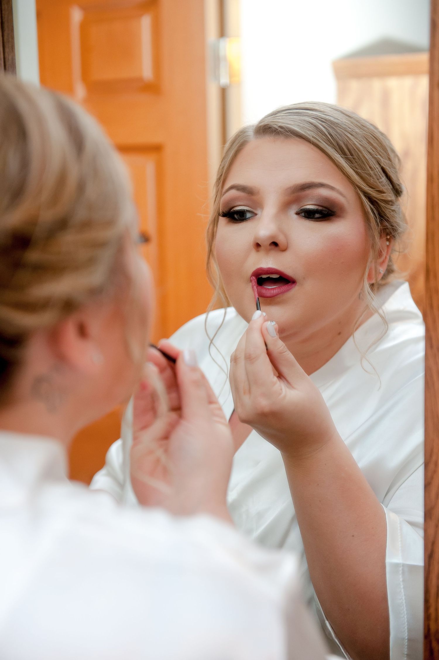 Close-up shots of bridal makeup application against orange background.