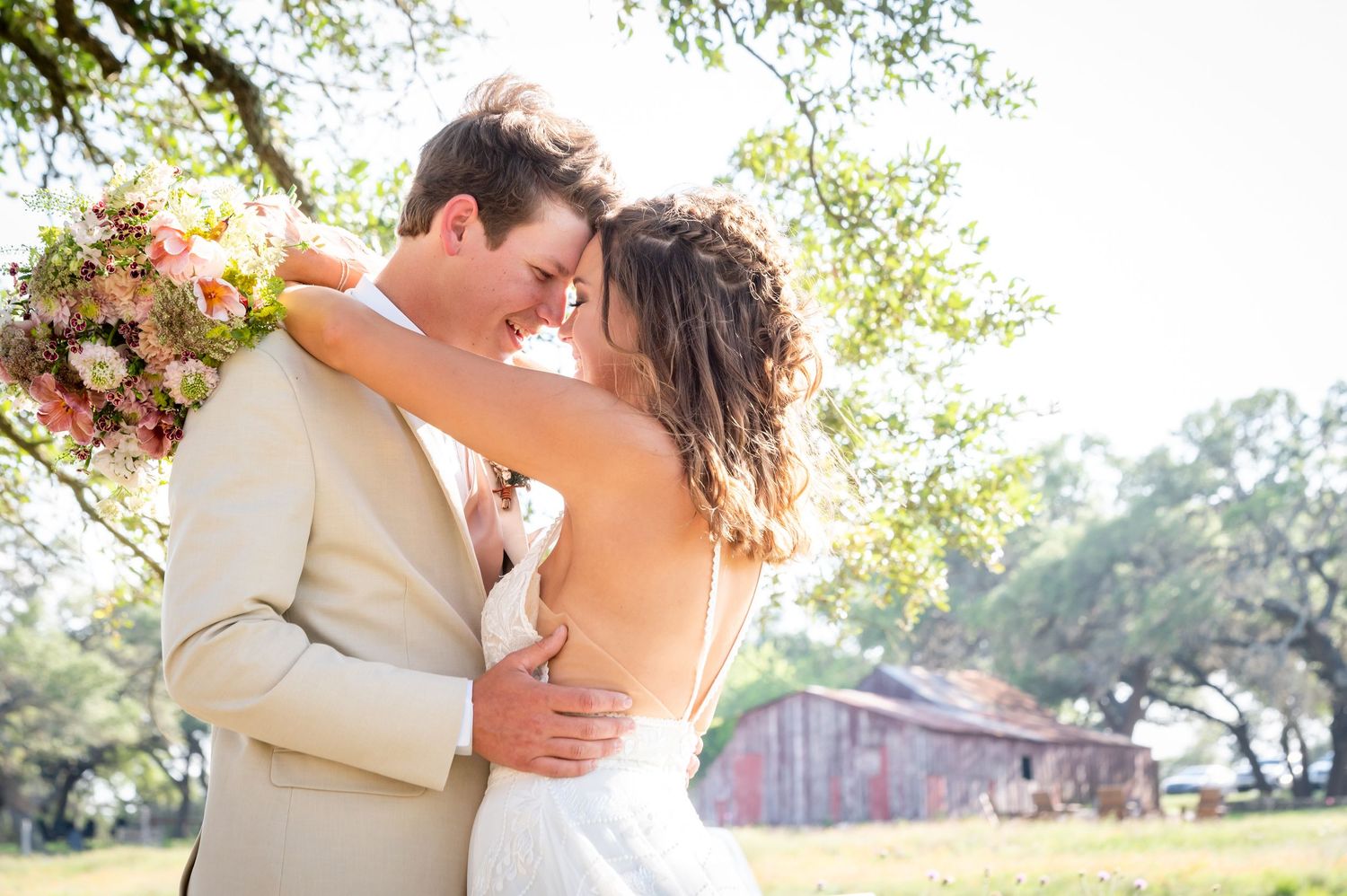 Romantic outdoor wedding portraits with rustic barn backdrop in golden sunlight.