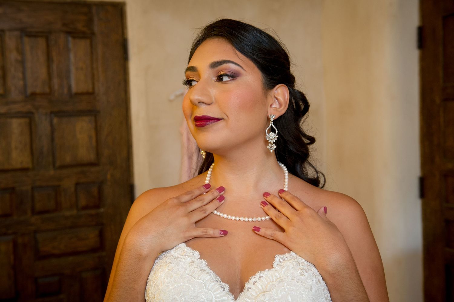 Elegant bridal portrait showcasing pearl necklace and dangling earrings with strapless wedding gown.