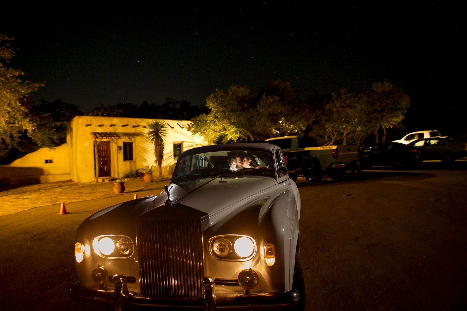 Luxury vintage cars illuminated at night create an elegant wedding exit scene.