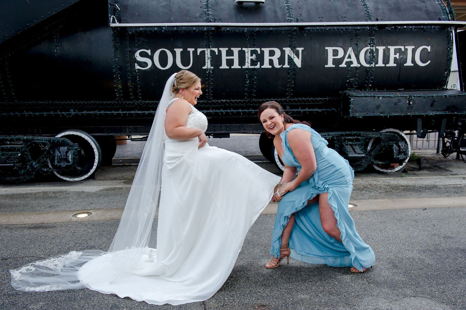 Wedding party members in light blue sit casually by a Southern Pacific train.