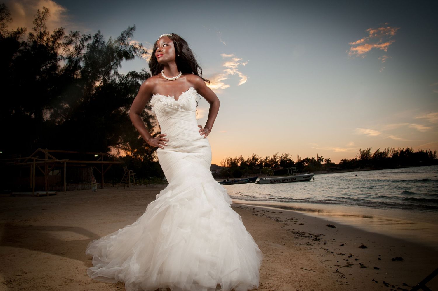Beach wedding photography session at sunset with flowing white gown on sandy shore.