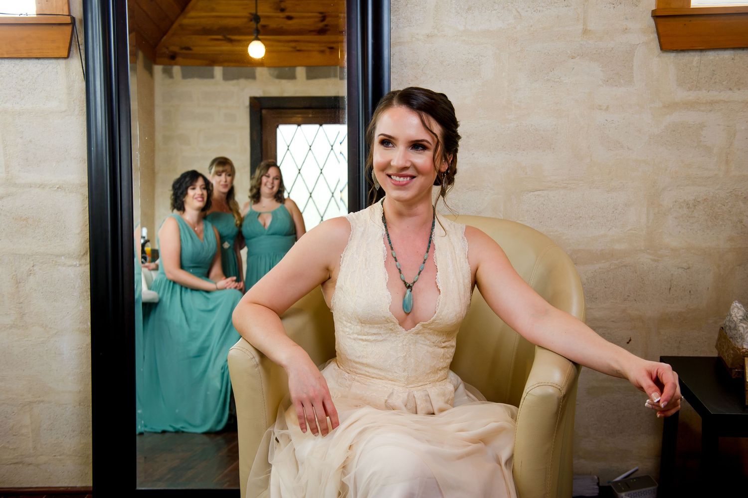 A wedding party getting ready in a rustic venue with stone walls and wooden beams.