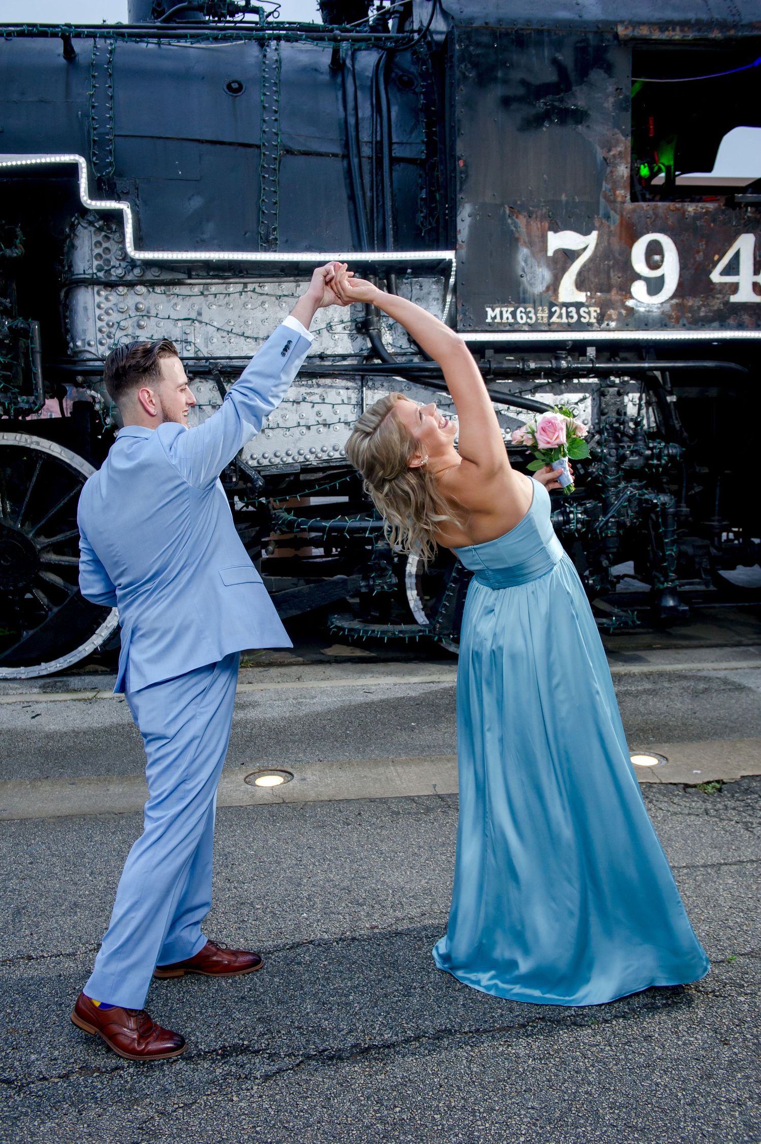 Playful wedding dance poses captured in sequence against vintage train.