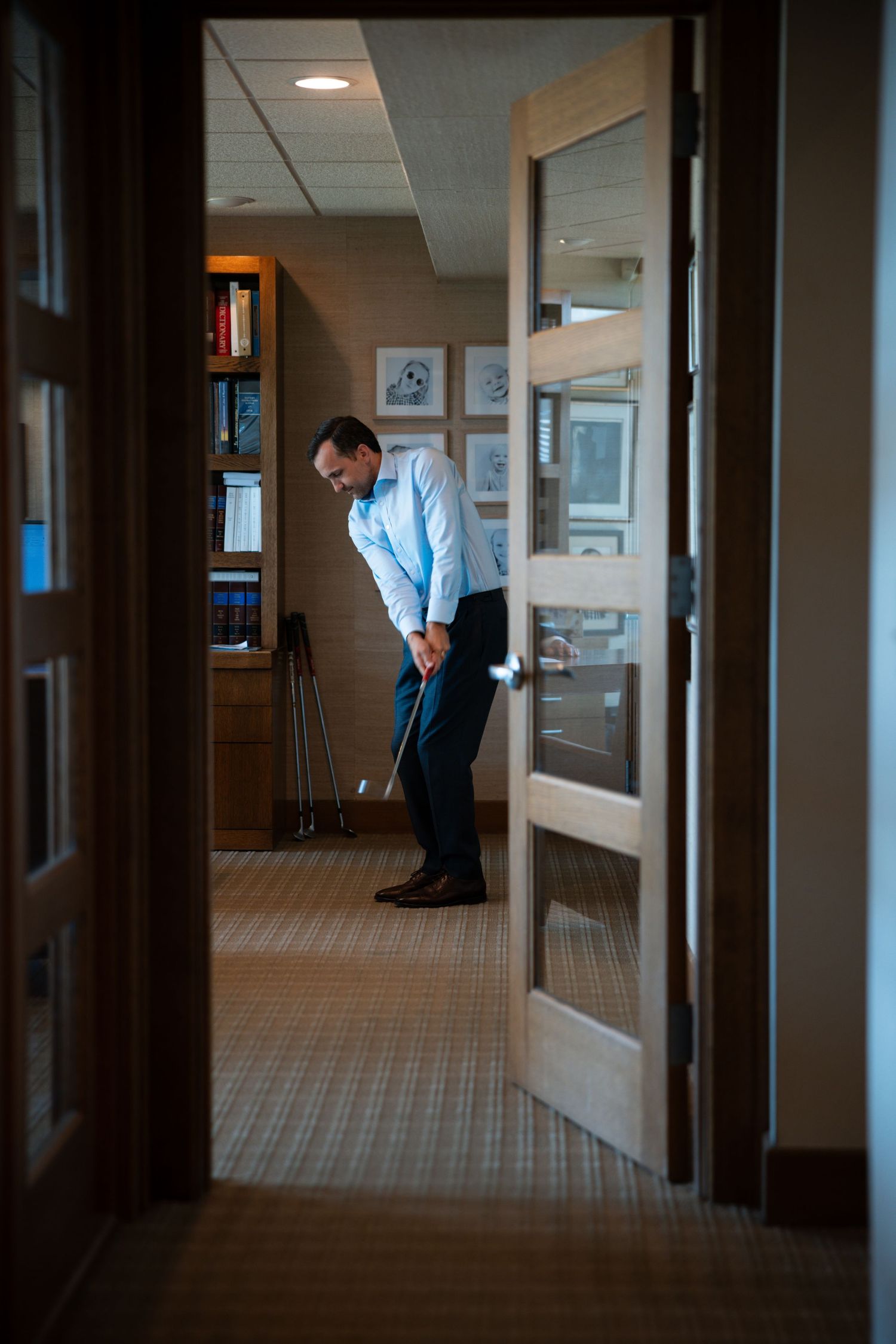 image of man in office swinging a golf club
