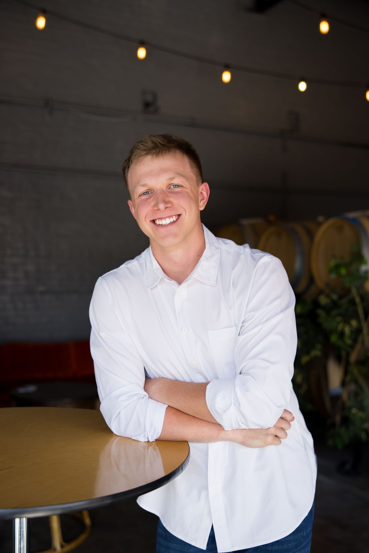 headshot of young man smiling with arms crossed