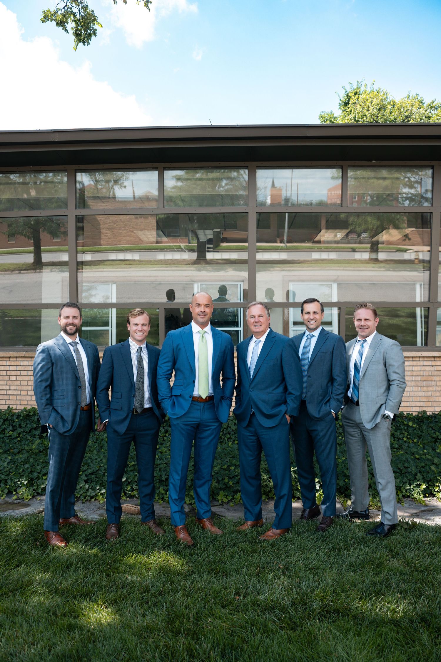 image of 6 men in suits outside office