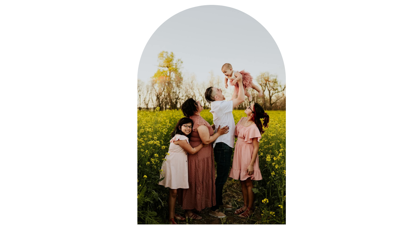 Happy family with children celebrating in a yellow wildflower field on a sunny day.