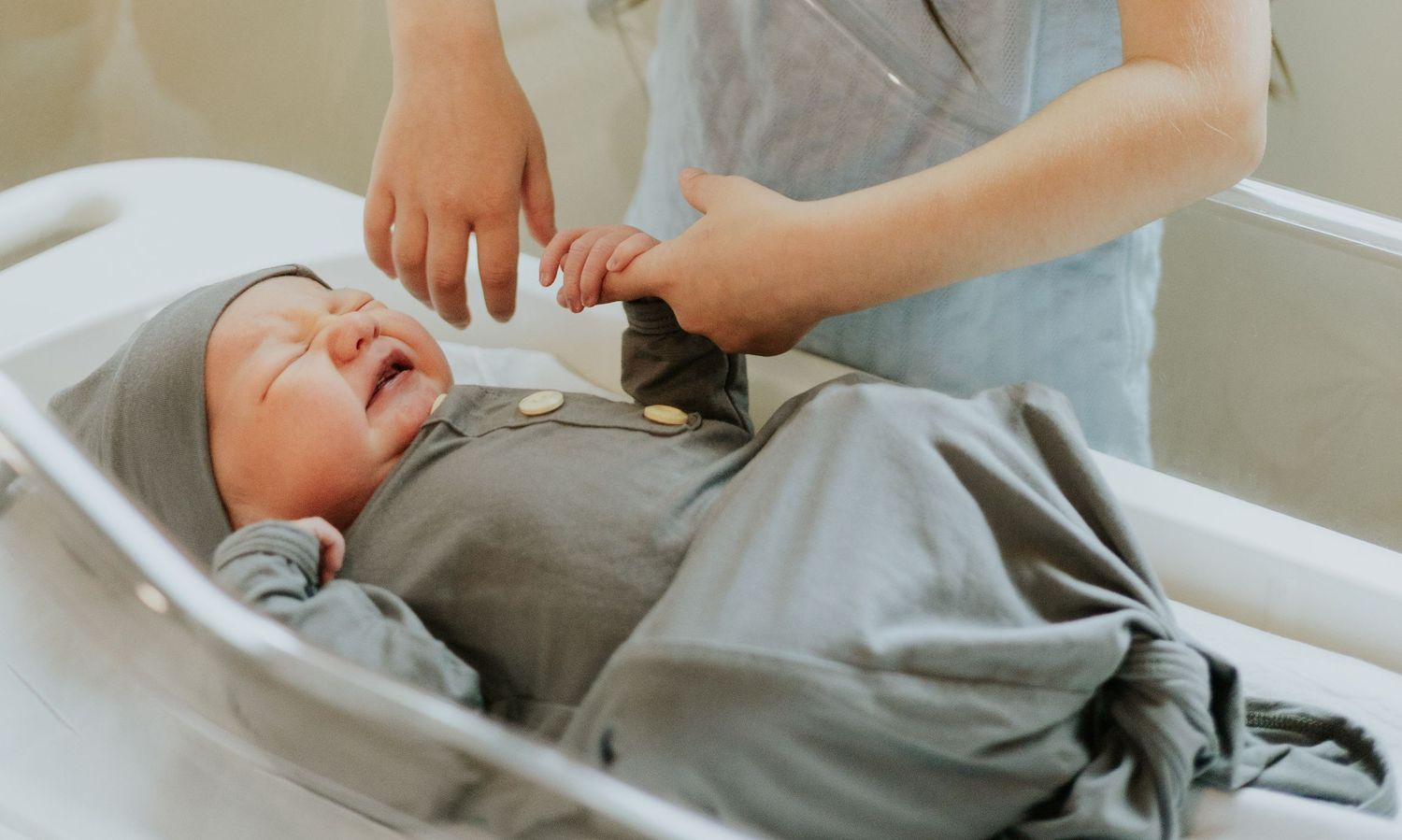 Newborn with sibling holding hand