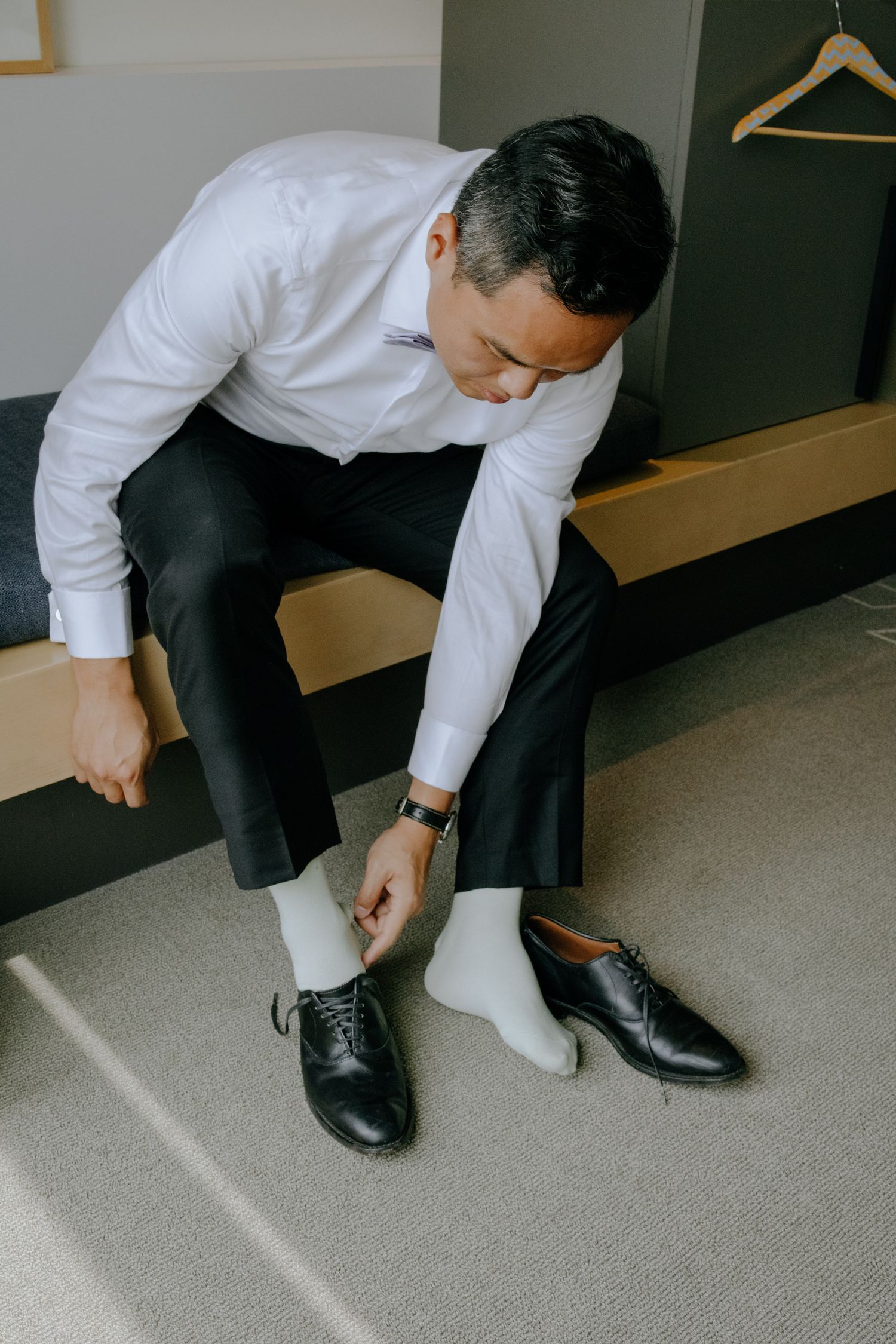 grooms portrait putting shoes in an hotel room in Ottawa