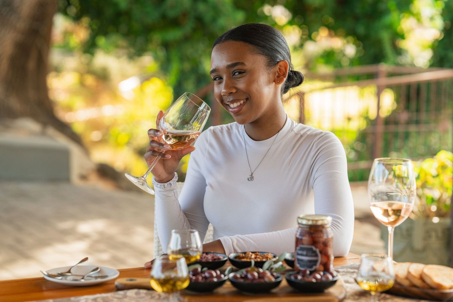 Outdoor dining scene with glassware and drinks in natural sunlight.