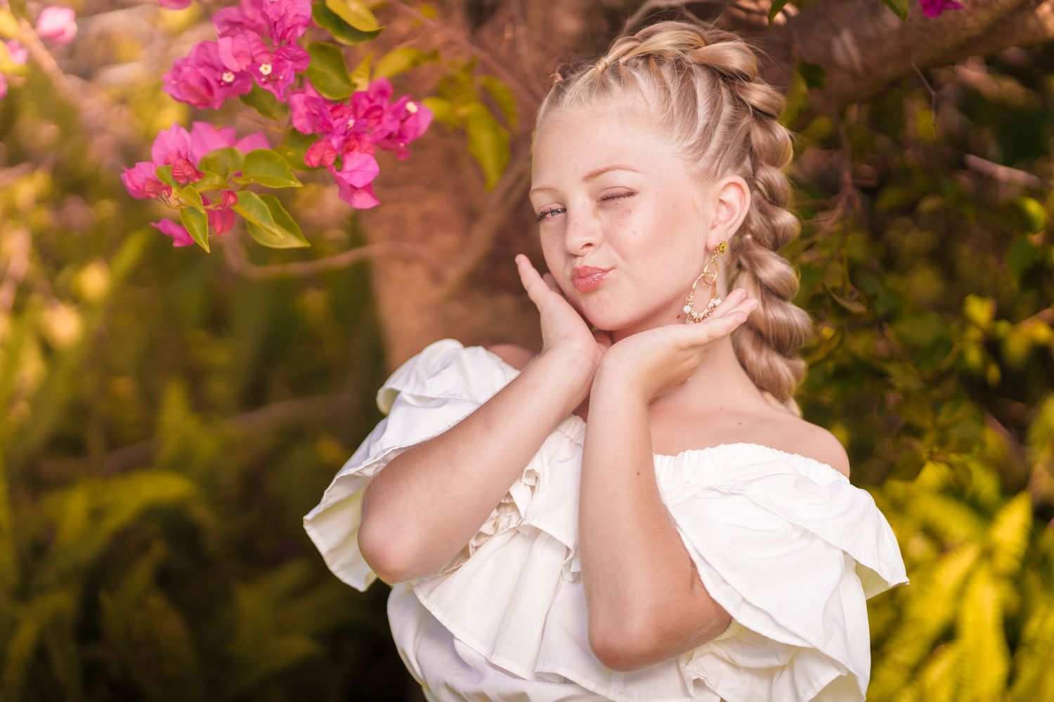 A couple shares a romantic moment in a garden setting with pink flowers and golden sunlight.