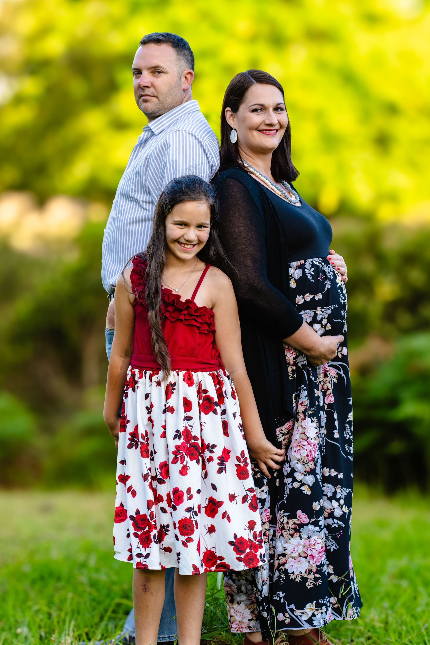Red and white floral dress captured in a bright outdoor garden setting.