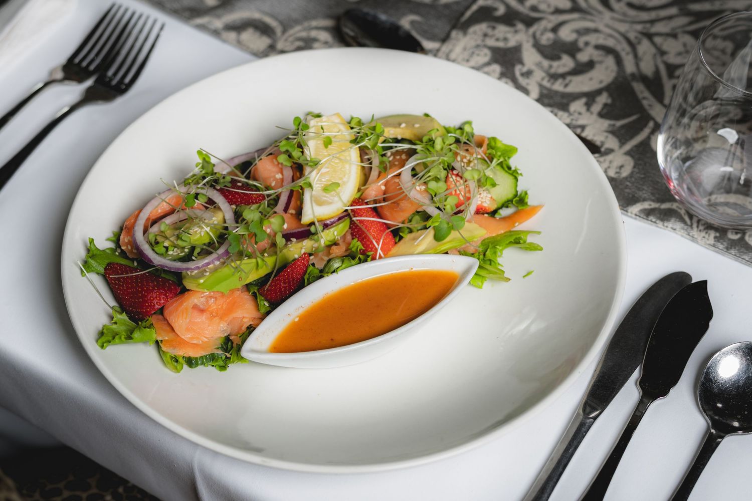 Elegant plated dishes with colorful garnishes on white restaurant dinnerware.