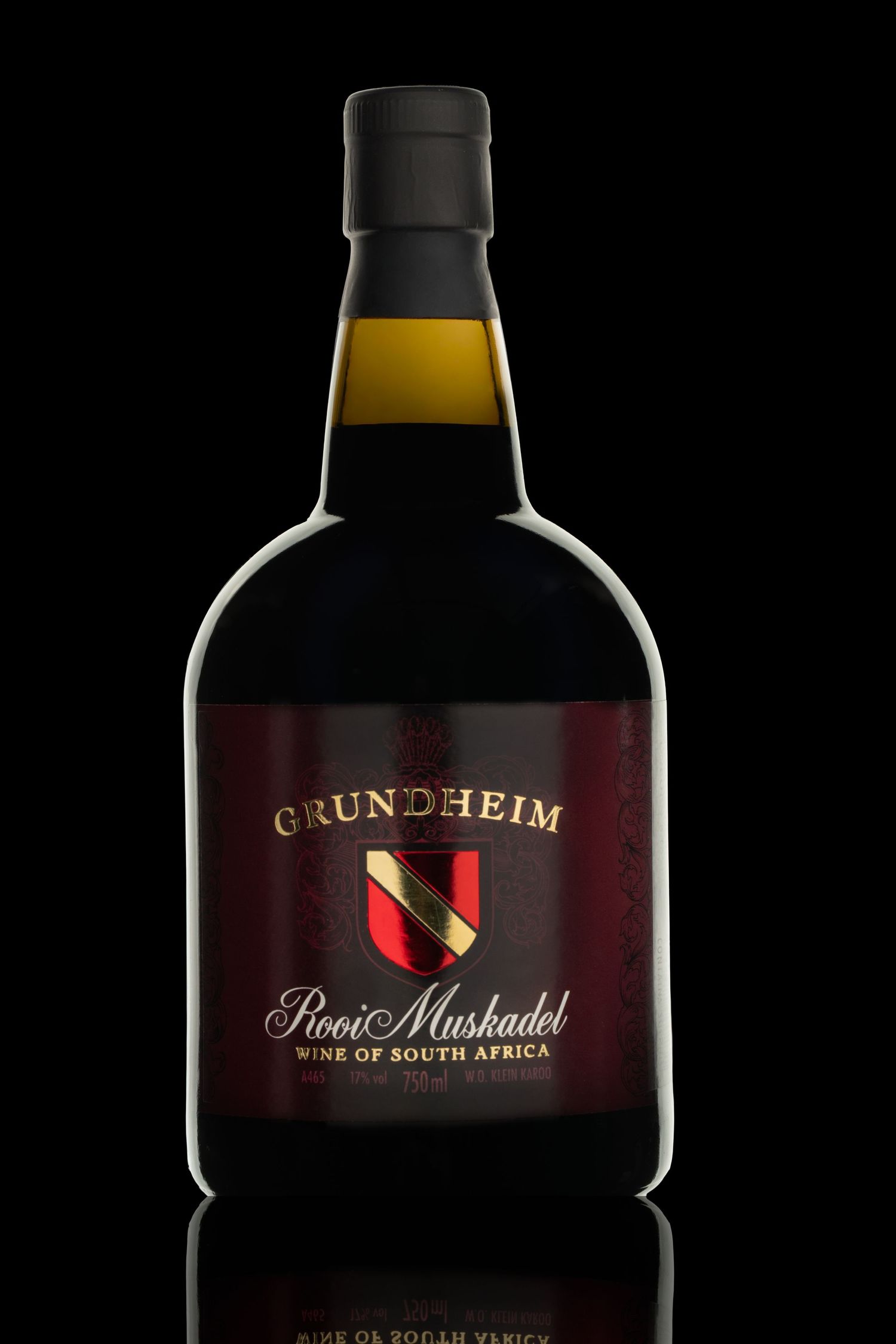 Grundheim wine bottles displayed with dramatic side lighting against black background.