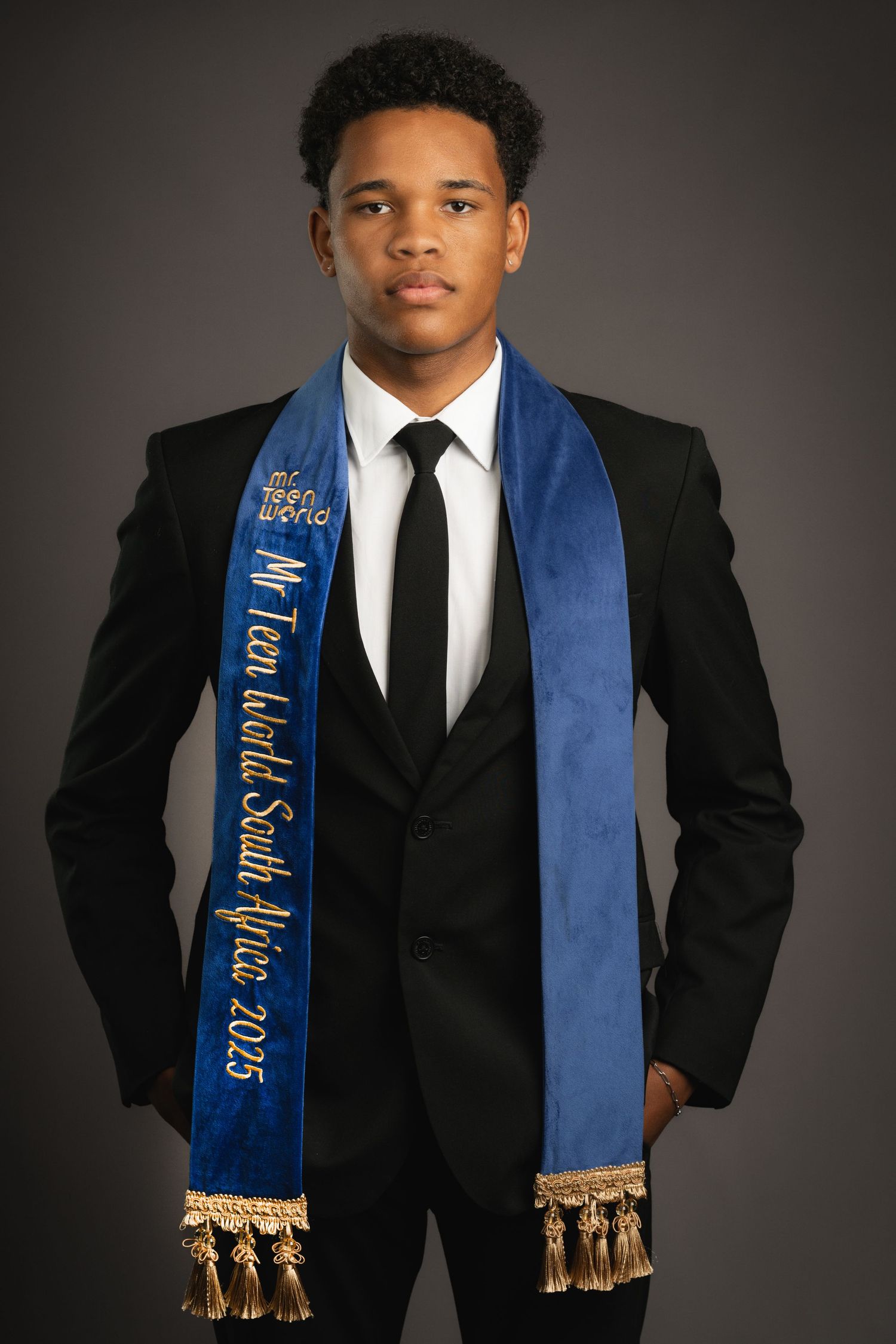 Formal portraits featuring someone wearing a black suit with blue graduation sash with gold tassels.