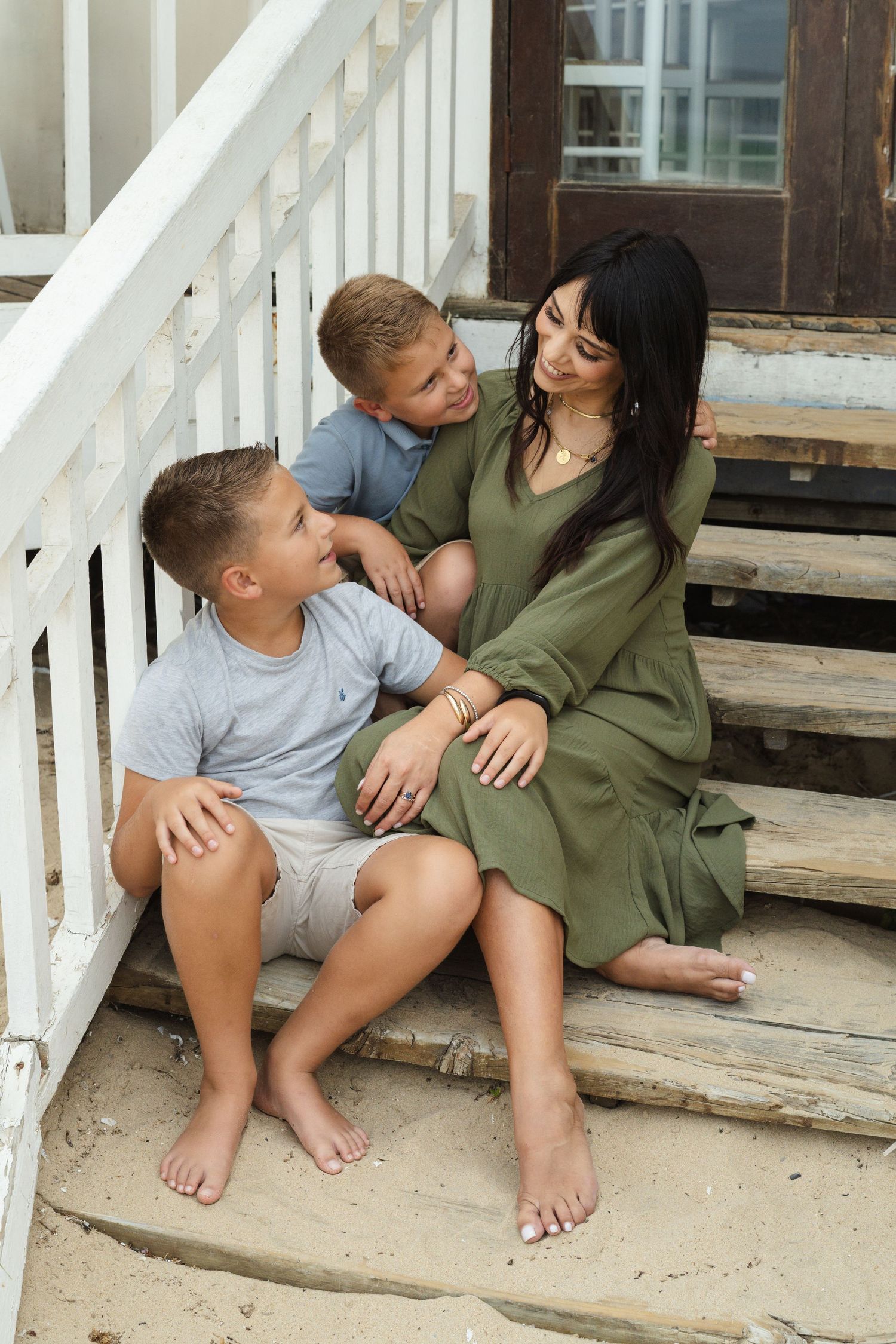 Candid moments captured on white wooden stairs during an outdoor photoshoot.