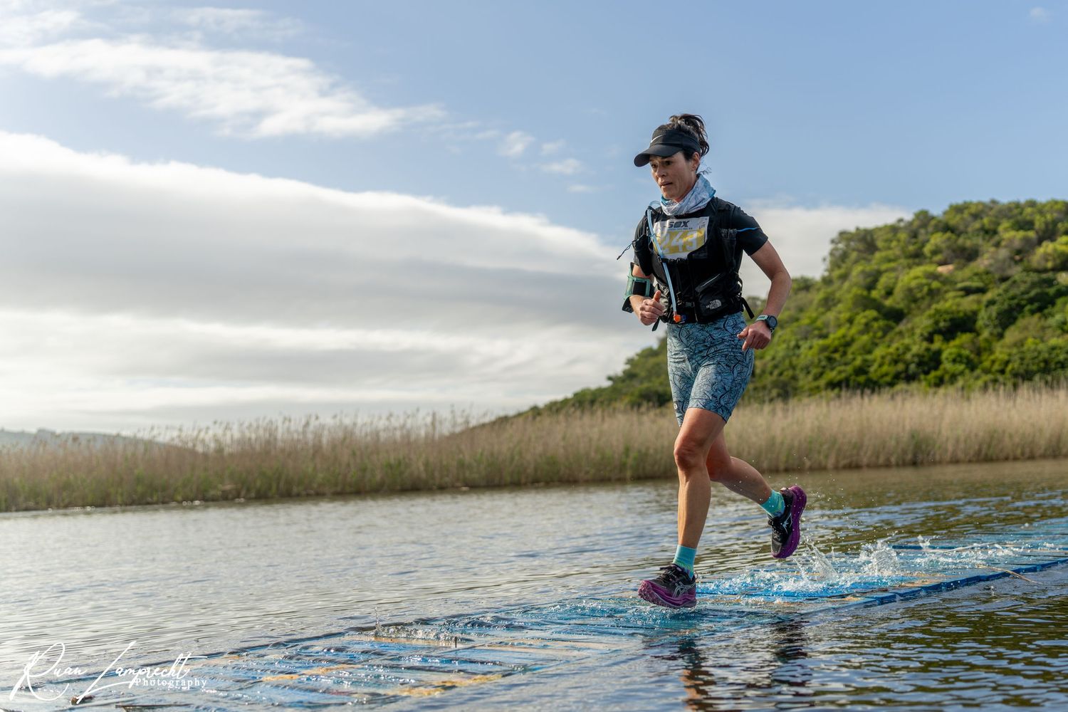 Runner running across a water bridge at the Souther Cross Trail Run in Wilderness, Garden Route