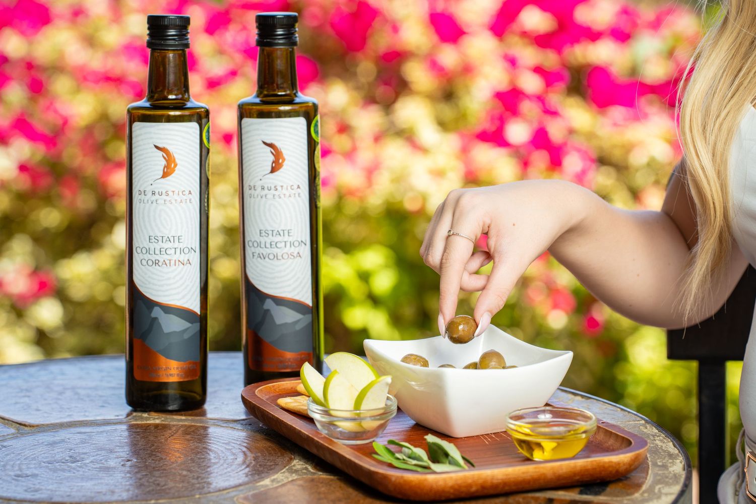 Mediterranean appetizer spread with olive oil and fresh ingredients in outdoor garden setting.