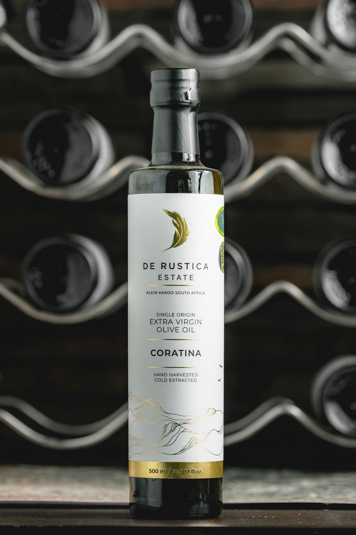 Olive oil bottles arranged in wine cellar storage racks with soft lighting.